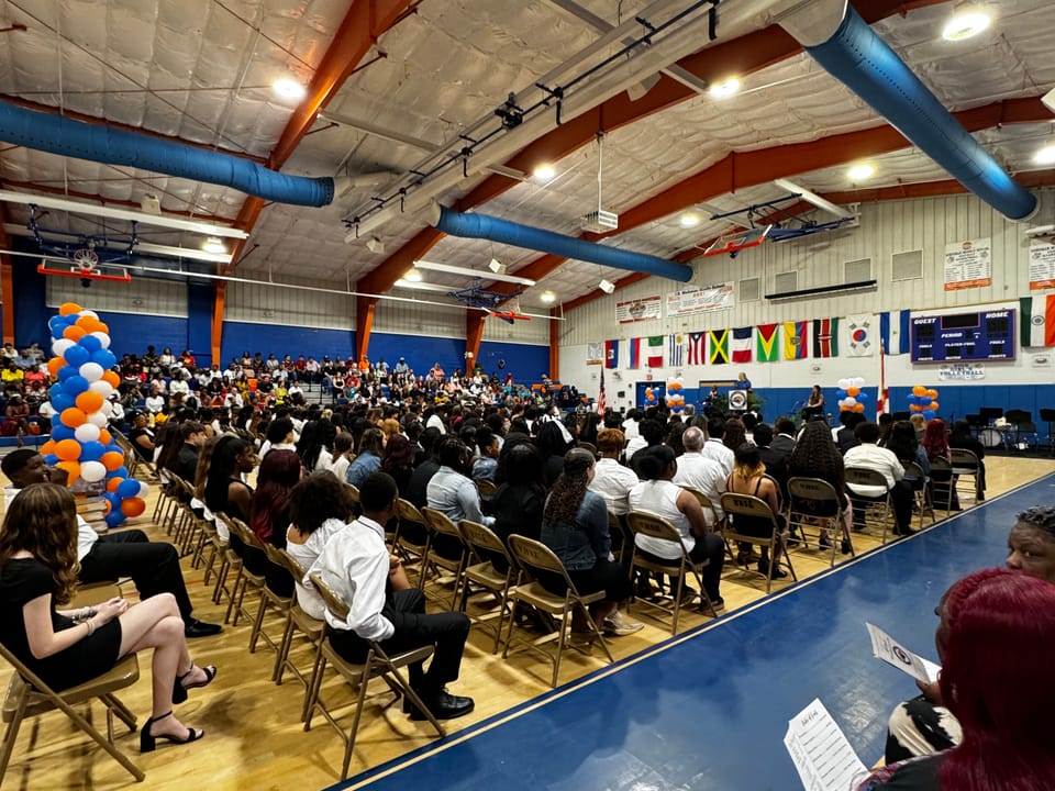 Eighth-grade students seated in the Workman Middle School gym for graduation in Pensacola.